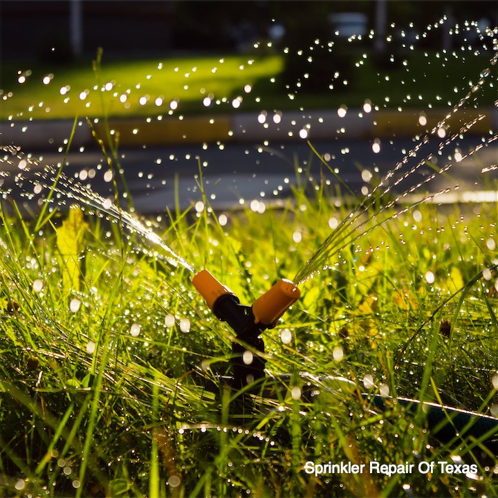 automatic-spinning-sprinkler-watering-green-grass-yard-soft-focus